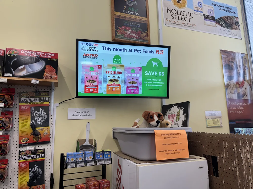 Wall-mounted screen at Pet Foods Plus in Bristol RI running the store's own monthly promotion