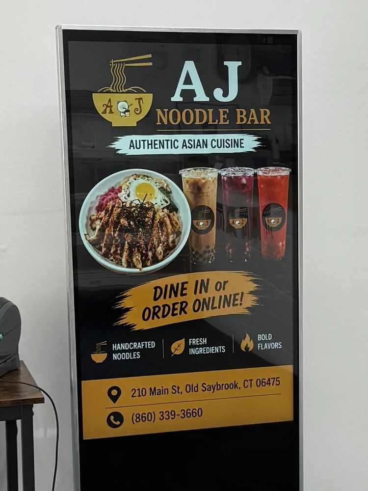 Freestanding floor totem in Connecticut running an ad for AJ Noodle Bar